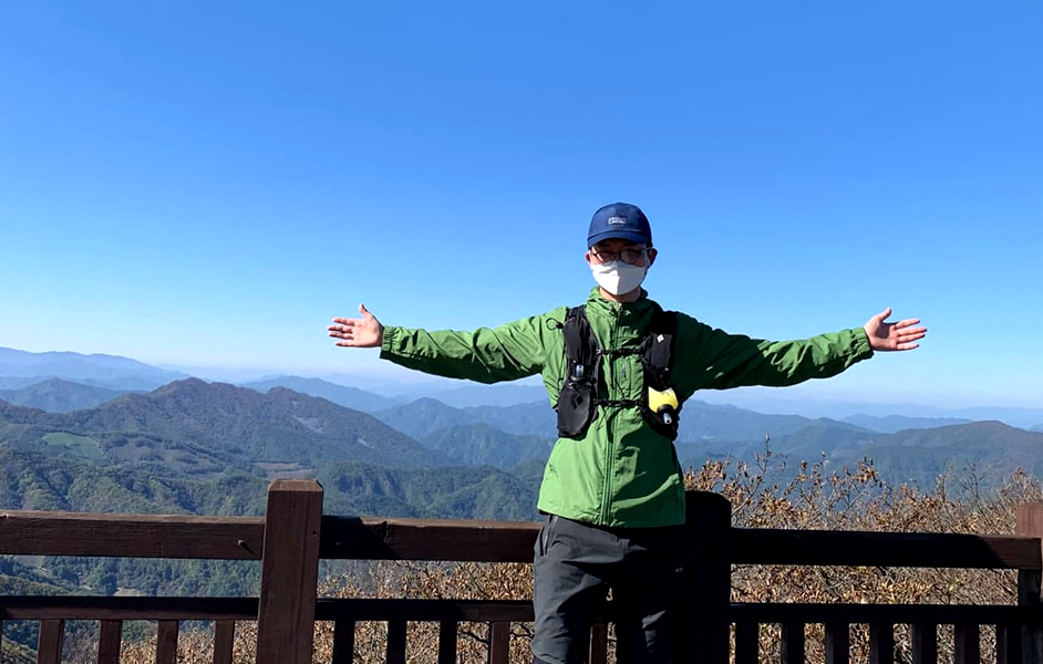 플랫폼 팀장이 산에 올라서 두팔을 벌리고 서 있다